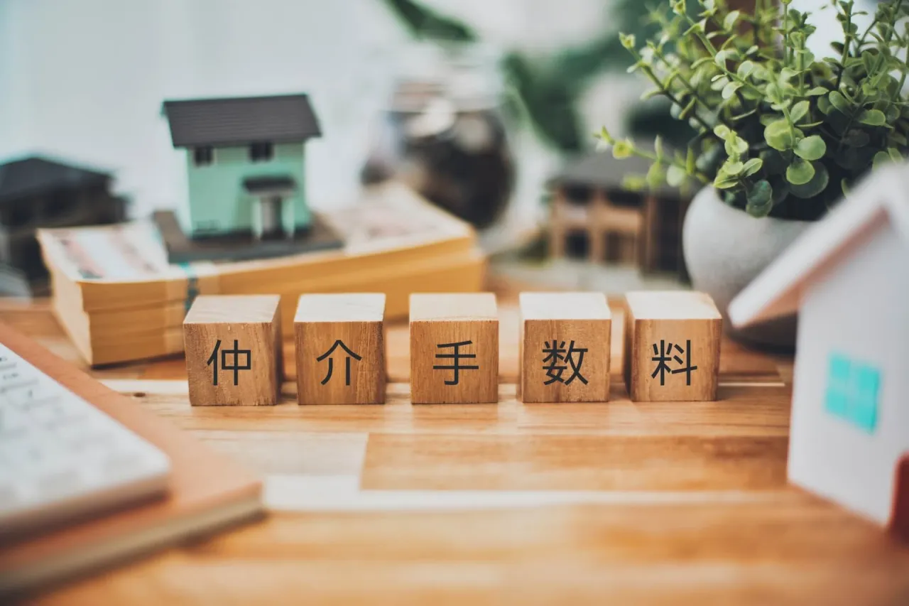 机上に並べられた家と経済の文字積み木