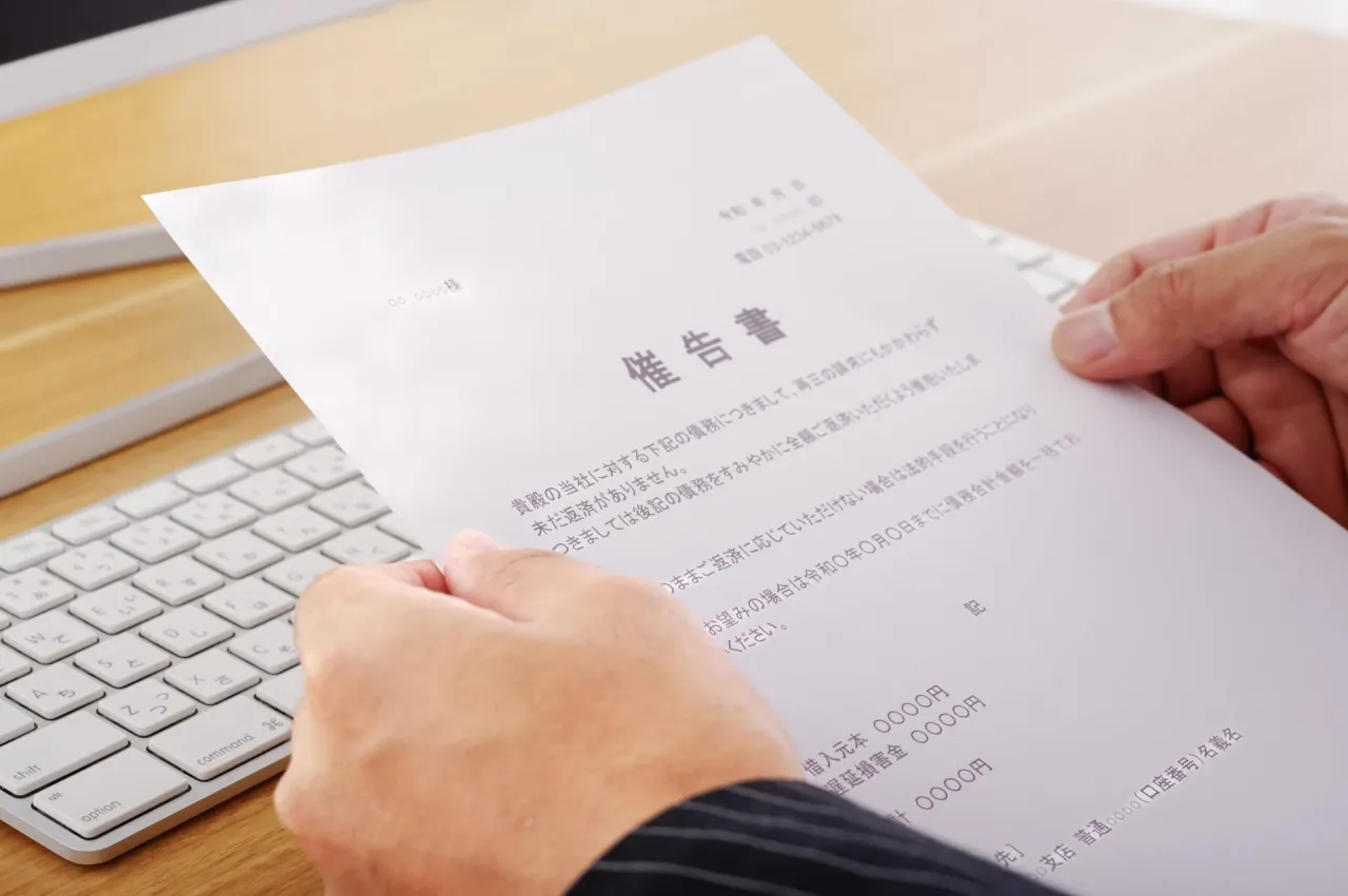 机上で書類を読む人の手元
